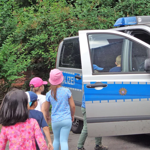 Kinder neben einem Polizeiauto